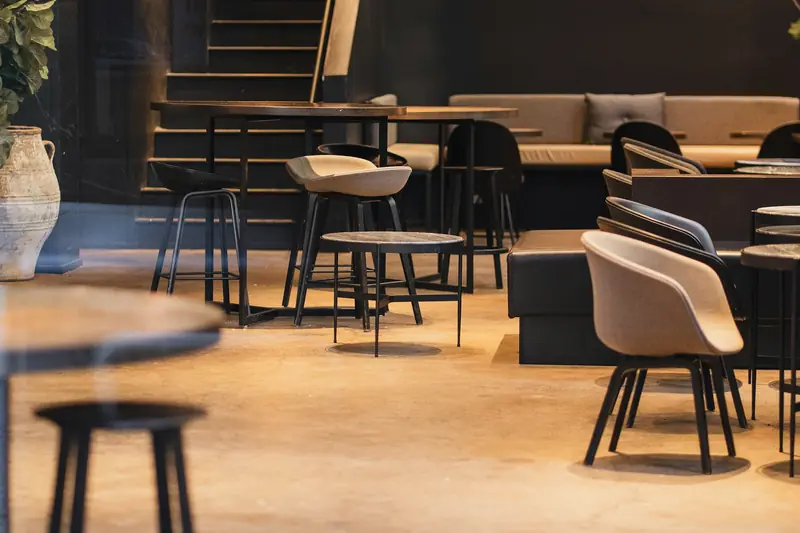 Warmly lit café interior with tables and stools