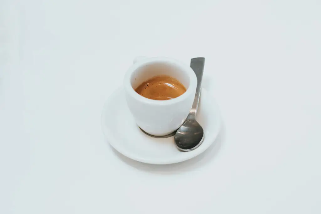 Espresso with crema in a small white cup on a saucer