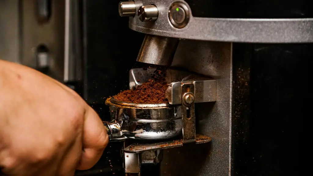 Espresso grinder dosing fresh grounds into a portafilter