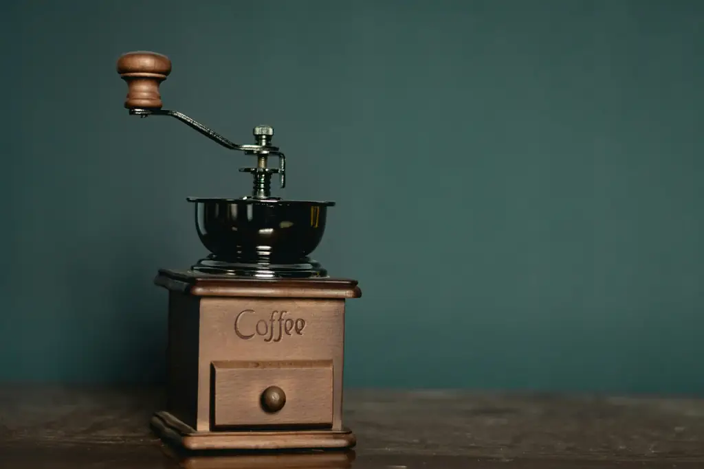 Hand coffee grinder with a crank on a wooden shelf