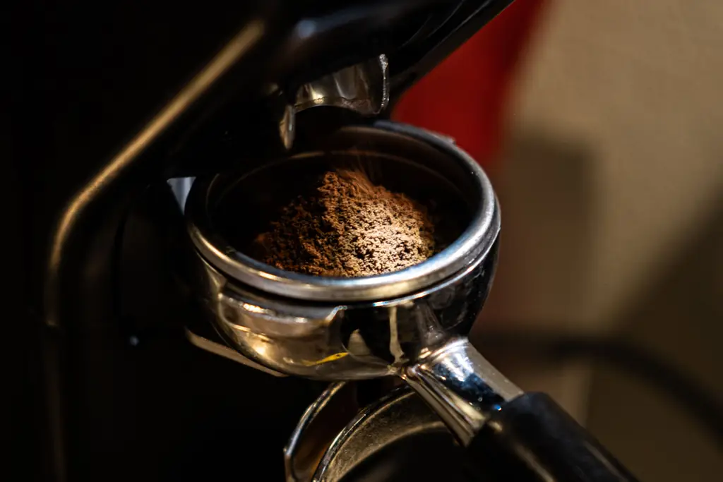 Espresso grinder dosing fresh grounds into a portafilter