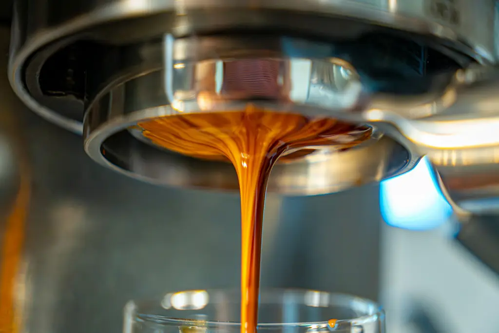 Close-up of espresso pouring from a portafilter into a glass